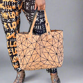 shoulder bag with cork piece cutouts shaped like triangles.