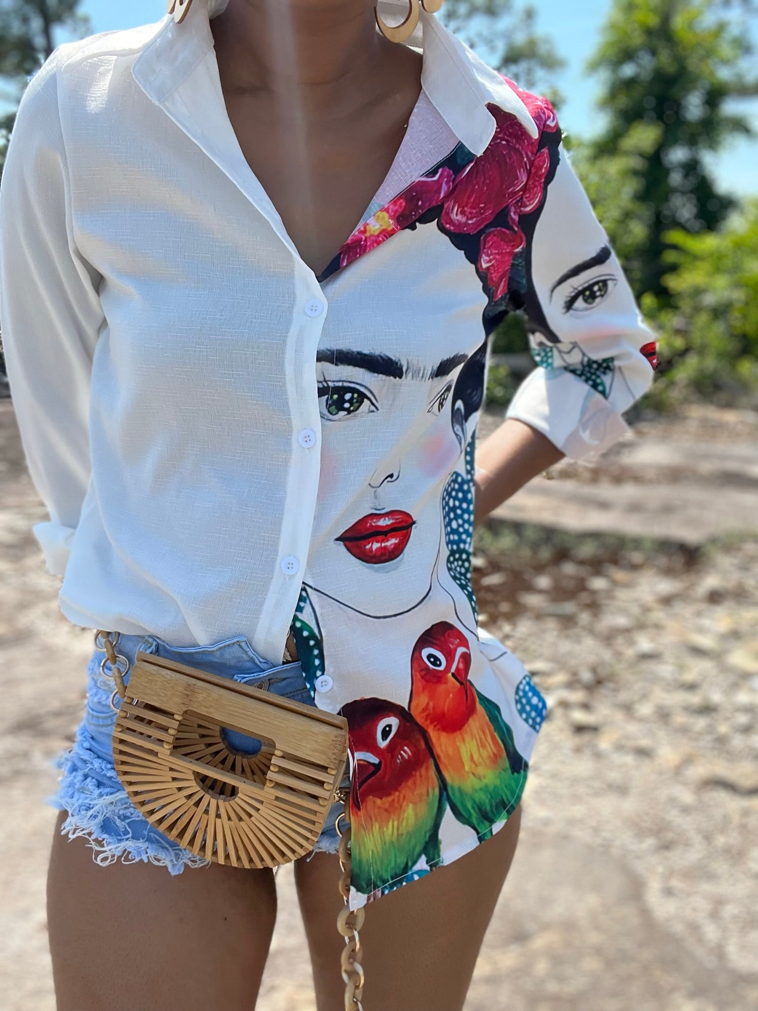 Frida Kahlo Paradise long sleeve button up blouse in white polyester, front view showing Frida with roses in her hair, parakeets, and cactus print