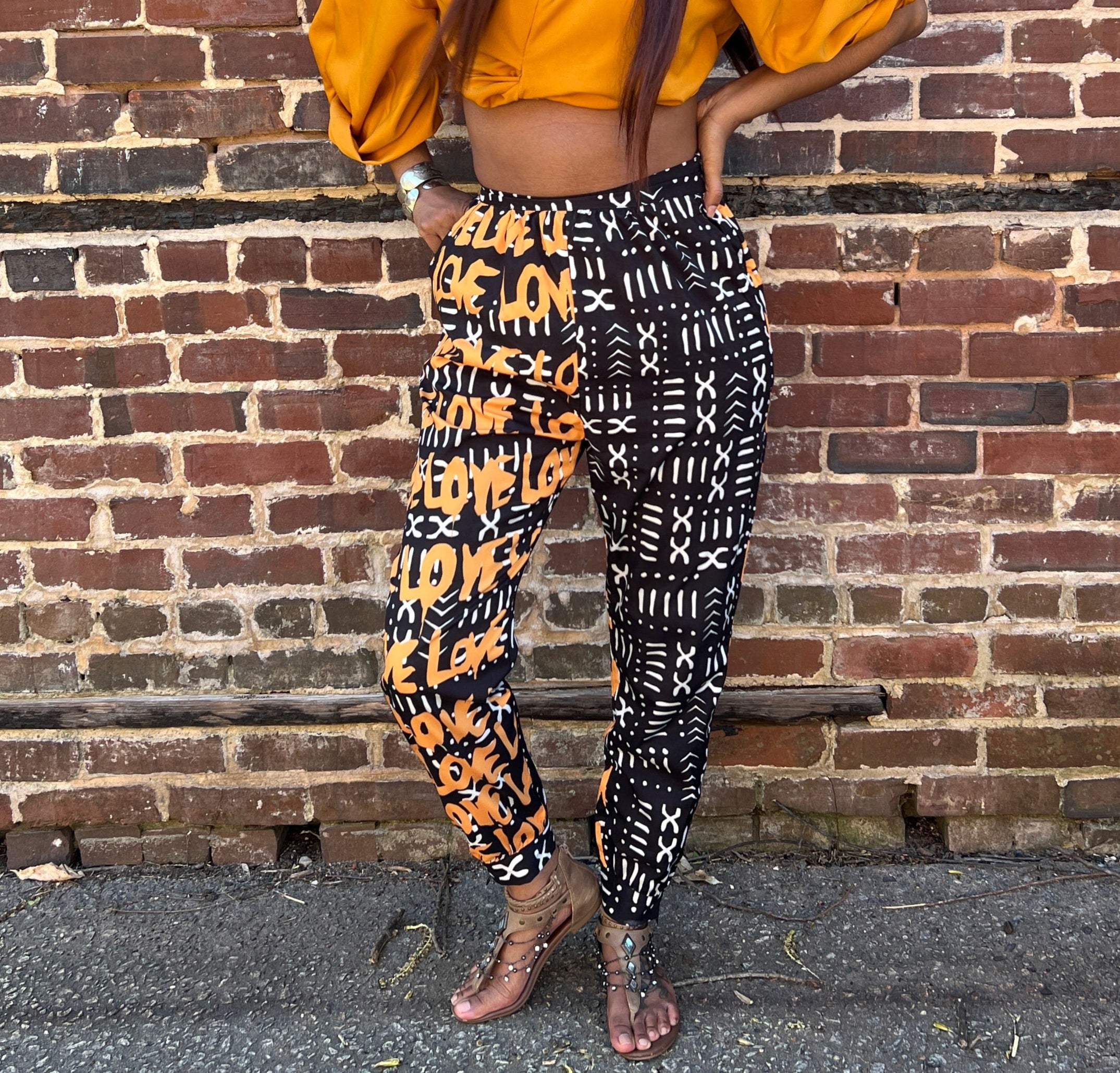 High-waist Jodhpur style pant with a black and white mud print and gold lettering on one side spellling LOVE.